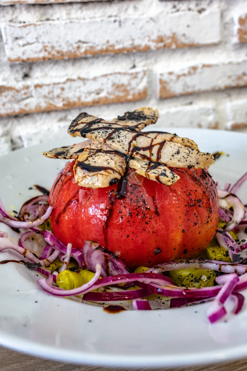 Tomate rosa entero con piparras, cebolla morada y ventresca de atún
